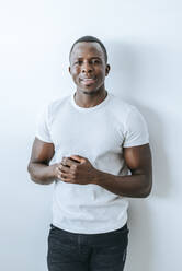 Portrait of confident young man in front of white wall - KIJF02620