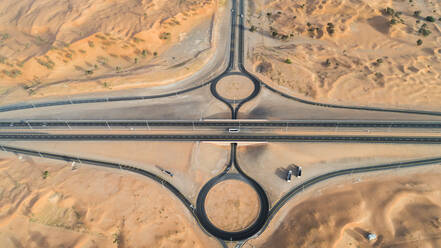 Luftaufnahme eines geometrischen Kreisverkehrs und von Straßen in der Wüste von Umm Al Quawain, Vereinigte Arabische Emirate. - AAEF03145