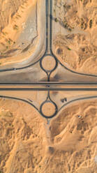 Luftaufnahme eines geometrischen Kreisverkehrs und von Straßen in der Wüste von Umm Al Quawain, Vereinigte Arabische Emirate. - AAEF03146