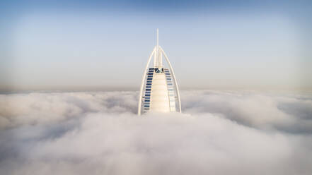 Aerial view of the luxurious Burj Al Arab hotel crossing the clouds of Dubai, U.A.E. - AAEF03152