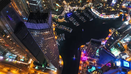 Luftaufnahme von beleuchteten Wolkenkratzern bei Nacht in Dubai, Vereinigte Arabische Emirate. - AAEF03258