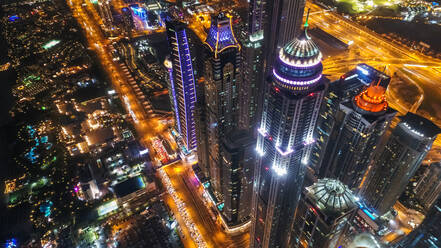 Luftaufnahme von beleuchteten Wolkenkratzern bei Nacht in Dubai, Vereinigte Arabische Emirate. - AAEF03261