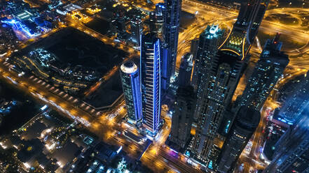 Luftaufnahme von beleuchteten Wolkenkratzern bei Nacht in Dubai, Vereinigte Arabische Emirate. - AAEF03262