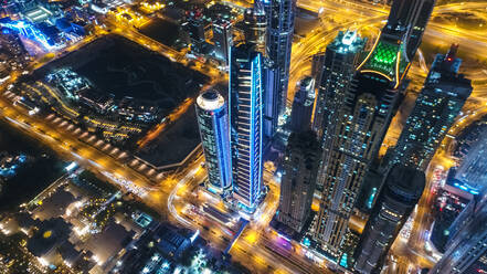 Luftaufnahme von beleuchteten Wolkenkratzern bei Nacht in Dubai, Vereinigte Arabische Emirate. - AAEF03263