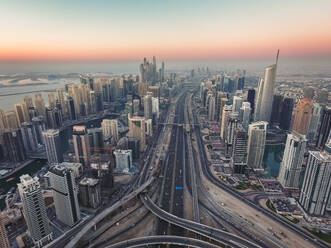 Luftaufnahme einer Autobahn durch Dubai bei Sonnenuntergang, Vereinigte Arabische Emirate. - AAEF03293