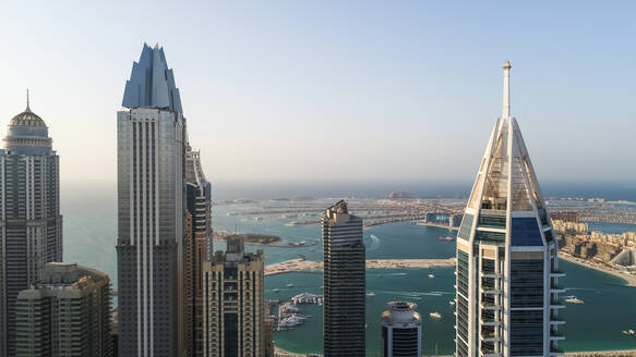 Luftaufnahme von Wolkenkratzern mit The Palm Jumeirah im Hintergrund, Dubai, Vereinigte Arabische Emirate. - AAEF03307