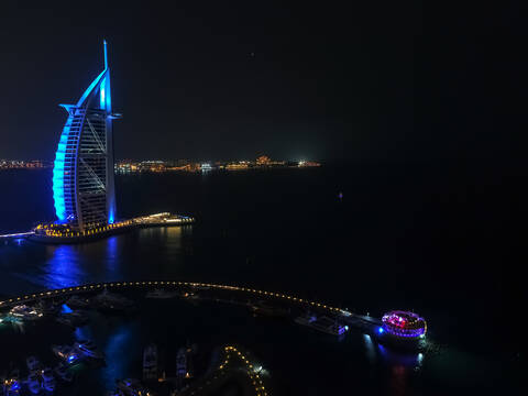 Aerial view of the luxurious Burj Al Arab Hotel by night in Dubai, United Arab Emirates. stock photo