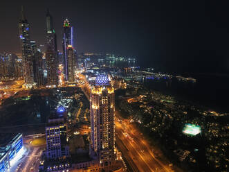 Luftaufnahme von beleuchteten Wolkenkratzern bei Nacht in Dubai, Vereinigte Arabische Emirate. - AAEF03327