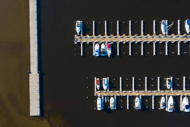 Luftaufnahme von Yachten und Segelbooten im späten Nachmittagssonnenlicht während des Frühlingsanfangs in einem Yachthafen in Michigan City, IN in den Vereinigten Staaten - AAEF03547