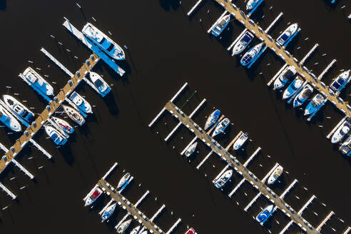 Luftaufnahme von Yachten und Segelbooten im späten Nachmittagssonnenlicht während des Frühlingsanfangs in einem Yachthafen in Michigan City, IN in den Vereinigten Staaten - AAEF03551