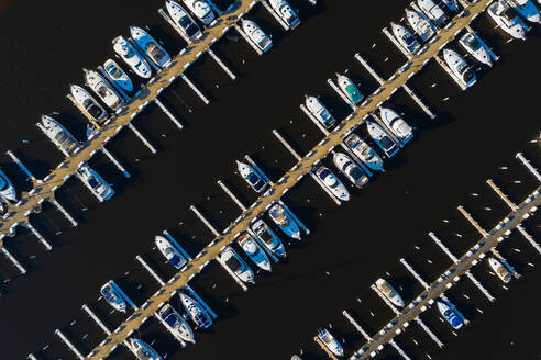 Luftaufnahme von Yachten und Segelbooten im späten Nachmittagssonnenlicht während des Frühlingsanfangs in einem Yachthafen in Michigan City, IN in den Vereinigten Staaten - AAEF03556