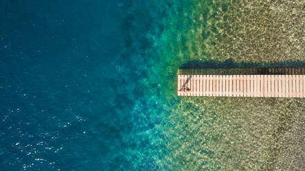 Luftbildaufnahme eines Jungen auf einem Ponton im Meer in Kiani Akti, Griechenland - AAEF03633