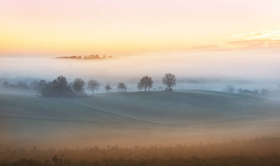 Layers of thick fog wafting across the rolling hills of Kraichgau region shortly after sunrise, Baden-Wurttemberg, Germany, Europe - RHPLF01163