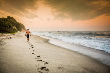 Mann beim Spaziergang am Strand im Tayrona-Nationalpark, Kolumbien, Südamerika - RHPLF01234