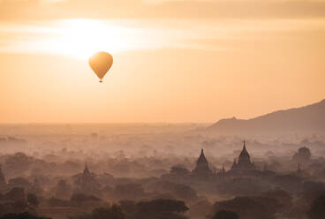 Blick auf Heißluftballon und Tempel bei Sonnenaufgang, Bagan (Pagan), Region Mandalay, Myanmar (Burma), Asien - RHPLF01340