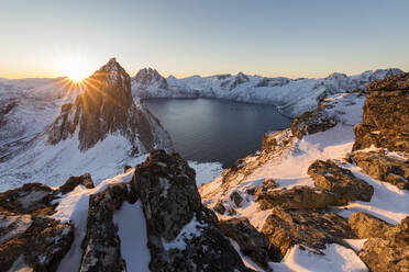 Das erste Licht des Sonnenaufgangs auf dem Berg Segla und dem Mefjorden, umrahmt vom gefrorenen Meer, gesehen vom Gipfel Hesten, Senja, Troms, Norwegen, Skandinavien, Europa - RHPLF01417