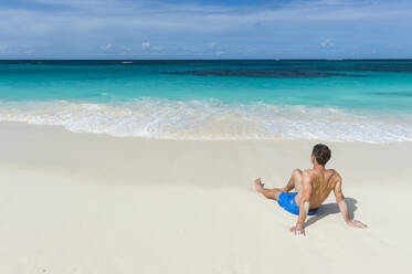 Ein Mann entspannt sich am Weltklasse-Strand von Shoal Bay East, Anguilla, Britisches Überseegebiet, Westindien, Karibik, Mittelamerika - RHPLF01437