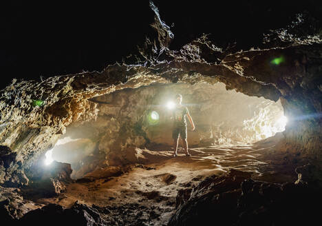 Tourist bei der Erkundung der Ana-Kakenga-Höhle, Nationalpark Rapa Nui, UNESCO-Weltkulturerbe, Osterinsel, Chile, Südamerika - RHPLF01480