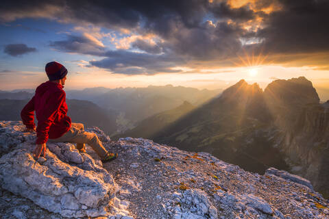 Wanderer betrachtet den Sonnenuntergang vom Piz Pordoi, Fassa Tal, Trentino, Dolomiten, Italien, Europa, lizenzfreies Stockfoto