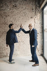 Senior and mid-adult businessman high fiving - GUSF02405