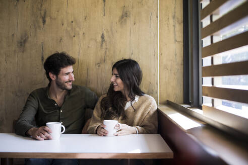Glückliches Paar trinkt Kaffee in einem Café - ABZF02429