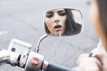 Spiegelbild einer jungen Frau, die Lippenstift aufträgt - ABZF02442