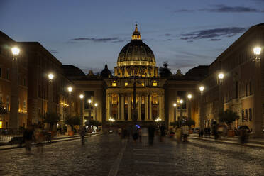 Nachtansicht des Petersdoms mit vorbeiziehenden Menschen, von der Via della Conciliazione, Rom, Latium, Italien, Europa - RHPLF01936