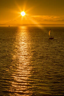 Segelboot und Sonnenuntergang über der Elliott Bay mit Bainbridge Island am Horizont vom Bell Harbour Marina aus gesehen, Seattle, Washington State, Vereinigte Staaten von Amerika, Nordamerika - RHPLF01979