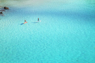 People paddleboarding on the emerald waters of Cala Mitjana, Menorca, Balearic Islands, Spain, Mediterranean, Europe - RHPLF02358