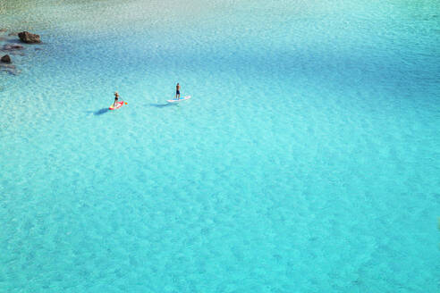 Menschen beim Paddeln auf dem smaragdgrünen Wasser von Cala Mitjana, Menorca, Balearen, Spanien, Mittelmeer, Europa - RHPLF02358