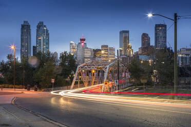 Car trail lights through Macdonal Avenue bridge and Downtown skyline at dusk, Calgary, Alberta, Canada, North America - RHPLF02389