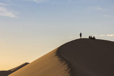 Menschen in Silhouette auf den Khongor-Sanddünen im Gobi-Gurvan-Saikhan-Nationalpark, Bezirk Sevrei, Provinz Südgobi, Mongolei, Zentralasien, Asien - RHPLF02740