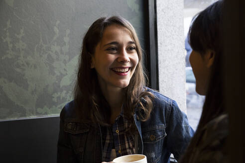 Junge Frauen sitzen in einem Café mit einer Tasse Kaffee - ABZF02458