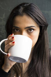 Junge Frau in einem Cafe mit einer Tasse Kaffee - ABZF02468
