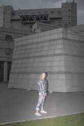 Mädchen in silbernem Anzug steht in einer futuristischen Stadt - VPIF01400
