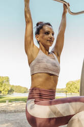 Frau hebt sich auf einem Fitnessparcours hoch - MFF04776