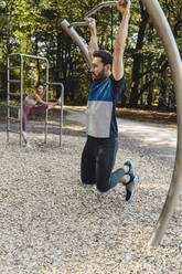 Mann hebt sich auf einem Fitnessparcours hoch - MFF04780