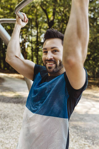 Porträt eines lächelnden Mannes, der sich auf einem Fitnessparcours aufrichtet, lizenzfreies Stockfoto