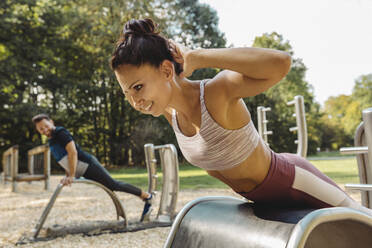 Woman doing push-ups on a fitness trail - MFF04822