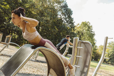 Woman doing push-ups on a fitness trail - MFF04823