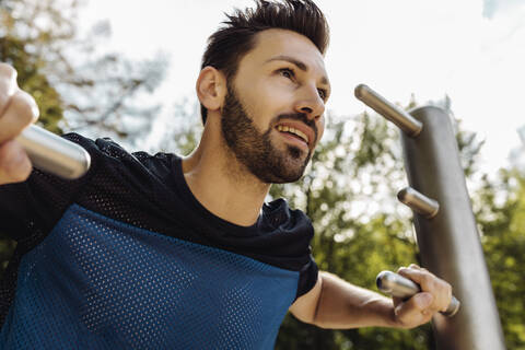 Porträt eines Mannes, der sich auf einem Fitnessparcours dehnt, lizenzfreies Stockfoto