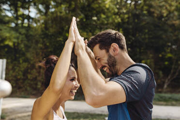 Man and woman high-fiving on a fitness trail - MFF04836