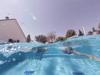 Zwei Frauen schwimmen in einem Pool - OCMF00579