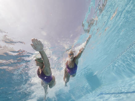 Zwei Frauen schwimmen in einem Pool - OCMF00580