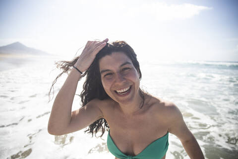 Porträt einer glücklichen Frau vor dem Meer, Fuerteventura, Spanien, lizenzfreies Stockfoto