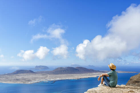 Man on viewpoint looking to La Gracioas island from Lanzarote, Canary Islands, Spain - KIJF02631