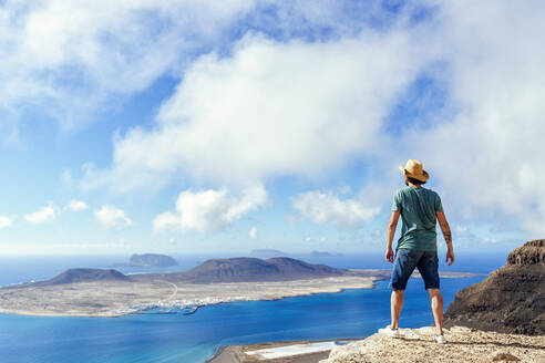 Man on viewpoint looking to La Gracioas island from Lanzarote, Canary Islands, Spain - KIJF02632