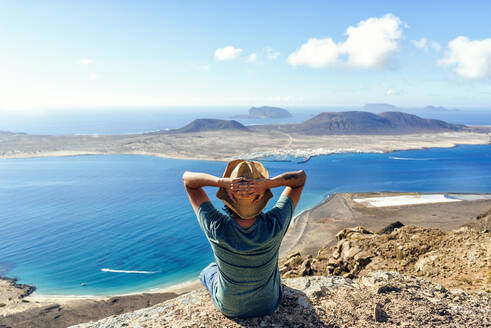Man on viewpoint looking to La Gracioas island from Lanzarote, Canary Islands, Spain - KIJF02633