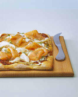 Nahaufnahme von Pizza mit Fenchel und Lachs auf dem Schneidebrett - PPXF00259