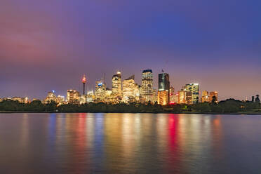 Beleuchtete Wolkenkratzer vor dem Fluss gegen den Himmel bei Nacht, Sydney, Australien - SMAF01326